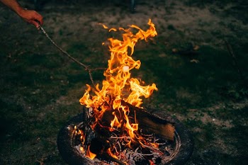 person burning twig on firepit