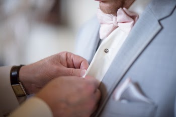 Person Buttoning a Man's Dress Shirt