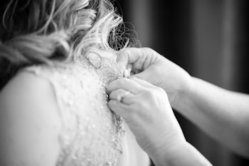 Person Buttoning Shirt on Woman's Back in Grayscale Photo