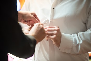 Person Buttoning White Dress Shirt