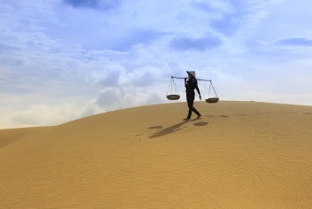 Person Carrying Basin on Brown Field