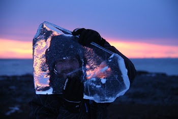 Person Carrying Block of Ice While Standing on Hill
