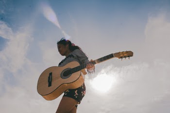 Person Carrying Brown Acoustic Guitar 