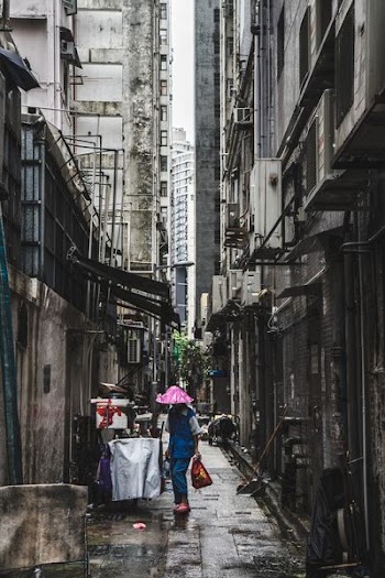 person carrying red bag in alley