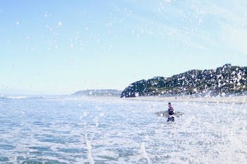 Person Carrying Surfboard Walking on Sea Water