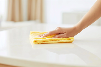 Person Cleaning Glossy Tabletop with Microfiber Cloth