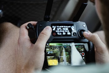 Person Controlling Drone Using Black Remote Control