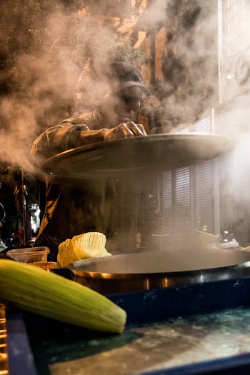 Person Cooking Corn in a Commercial Griddle