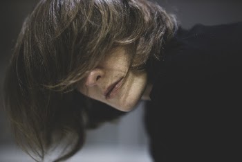 Person Covering Eyes With Hair