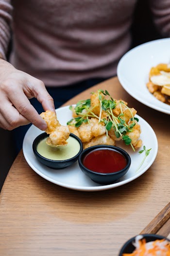Person Dipping Fried Food on Sauce