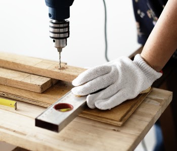 Person Drilling Hole On Wood