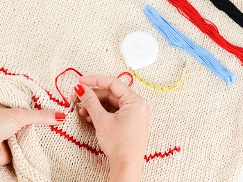 Person Embroidering a Beige Textile