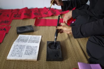 Person Filling Black Ink on Pen