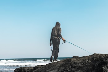 Person Fishing on Seashore