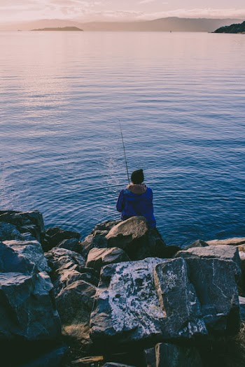 Person Fishing While Sitting at Daytime