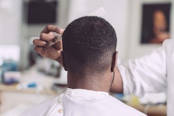 person fixing man's hair