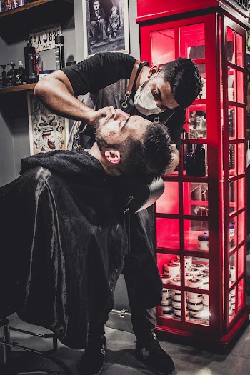 Person Getting Haircut Besides Red Telephone Booth