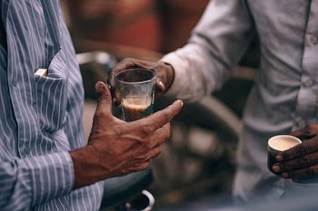 person handling drinking glass to a man