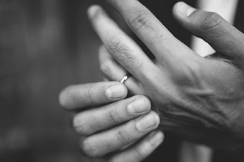 person hands wearing ring grayscale photo