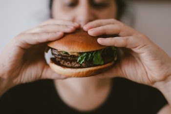 Person Holding a Burger