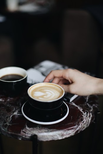 Person Holding A Cup Of Cappuccino