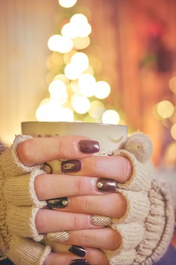 Person Holding a Mug Infront of a Lighted Christmas Tree