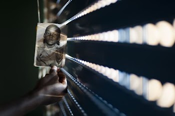 person holding a photo of boy in collared top
