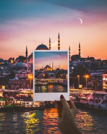 Person Holding a Photo of City Buildings