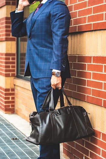 Person Holding a Zip Bag While Standing Near Concrete Wall