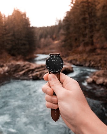 Person Holding Analog Watch Displaying 3:36