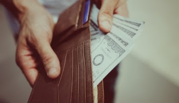 Person Holding And Showing 100 Dollar Bills From Leather Wallet