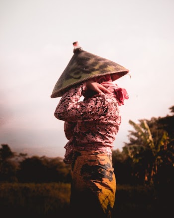 Person Holding and Wearing Hat