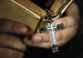 Person Holding Bible With Cross