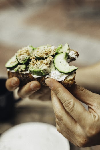 Person Holding Bitten Bread With Green Vegetables