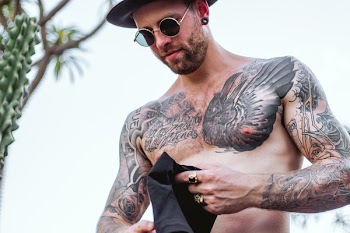 Person Holding Black Apparel Wearing Black Hat