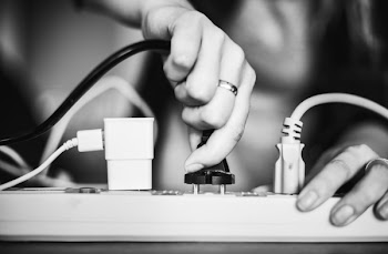 Person Holding Black Cable Wire and Power Strip