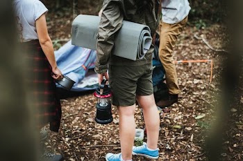 person holding black camping lantern