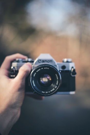 person holding black Canon DSLR camera