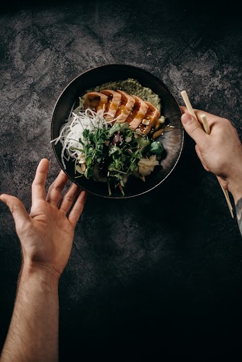 Person Holding Black Ceramic Bowl With Vegetable Salad