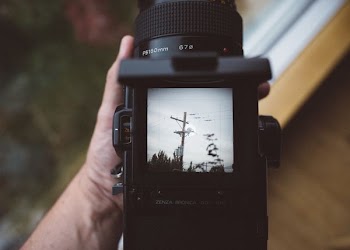 person holding black DSLR camera