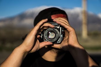 person holding black DSLR camera