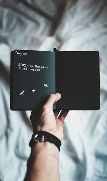 person holding black notebook
