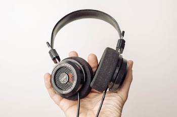 person holding black over-ear headphones