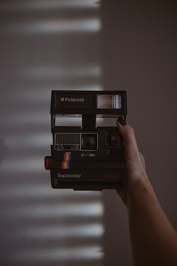 Person Holding Black Polaroid Instant Camera