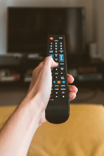 Person Holding Black Remote Control