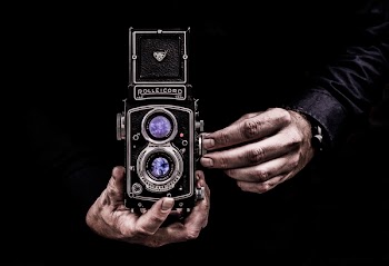 Person Holding Black Twin-lens Reflex Camera