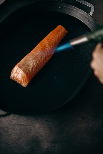 Person Holding Blue and Silver Pen and Orange Carrot