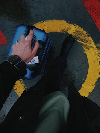 Person Holding Blue Luggage