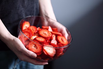 Person Holding Bowl of Slice Strawberries