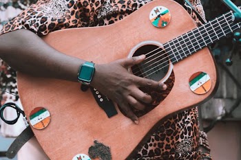person holding brown and black guitar